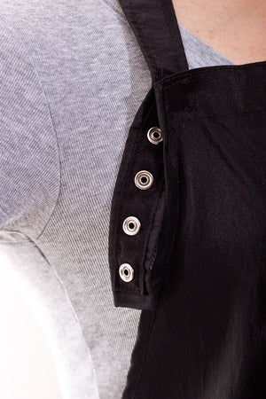 Detail of adjustable neck snaps on Ava - saloncapes.com's High Performance, Iridescent Polyblend Hair Stylist Apron in Black