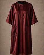 Burgundy iridescent snap-front salon robe front view with black collar trim, short sleeves and front pockets