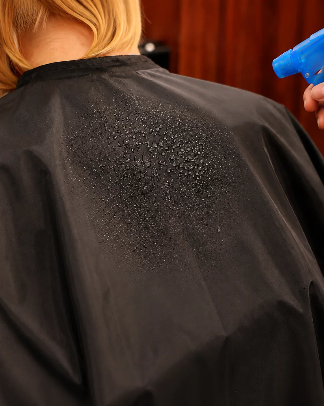 Water beading on black waterproof SalonCapes chemical cape fabric