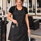 SalonCapes waterproof chemical apron with three lower pockets holding styling tools and sectioning clips