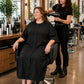 Black Crepe Snap-Front Client Robe worn during salon blow-dry styling service