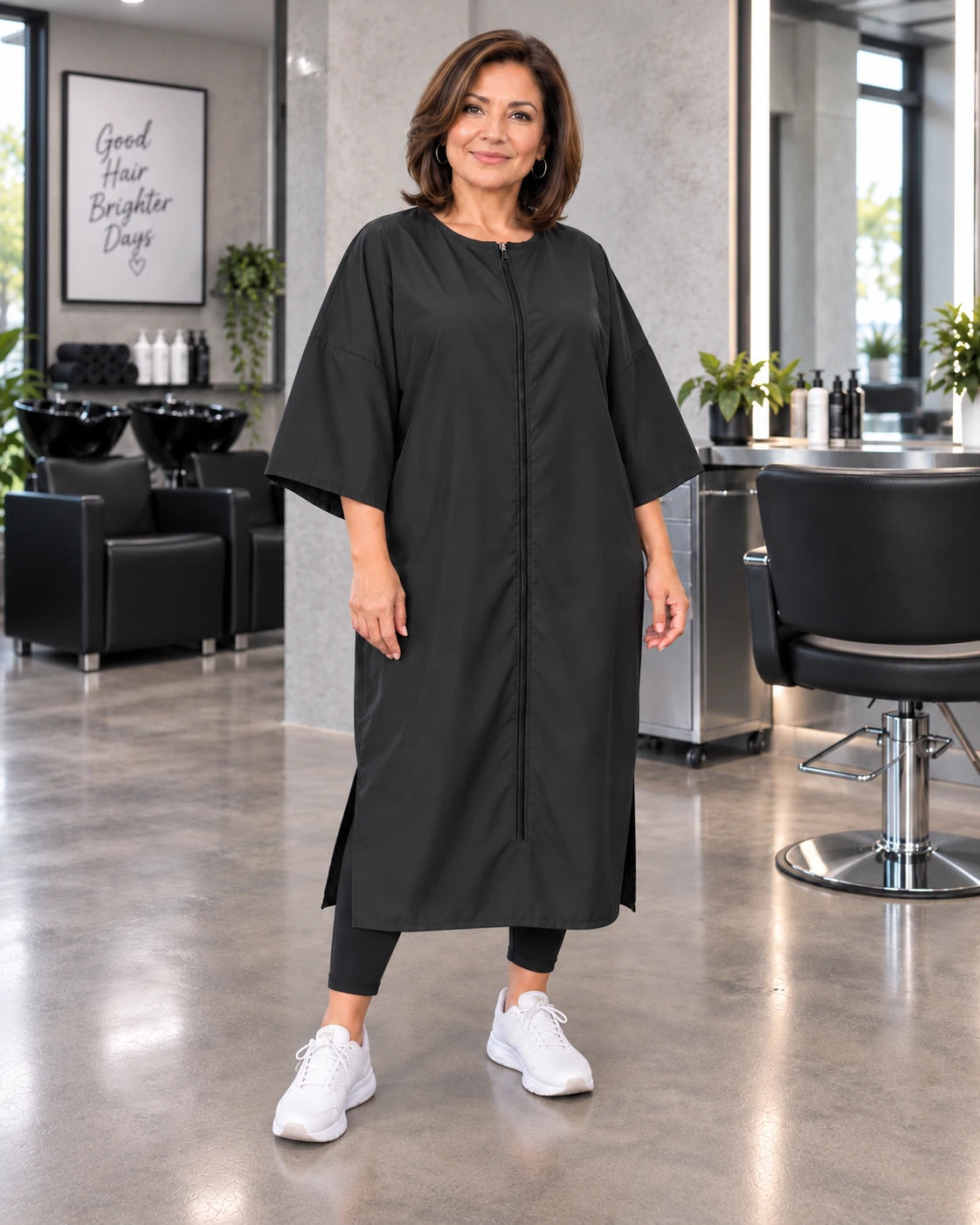 Black crepe zipper-front salon robe on woman standing in modern salon