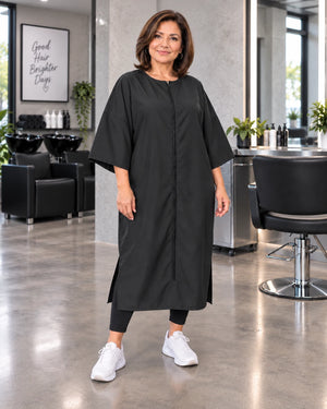Black crepe zipper-front salon robe on woman standing in modern salon