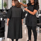 Black crepe zipper-front salon robe with waterproof upper-back panel and water droplets