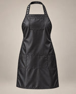 Black SalonCapes iridescent apron with chest pocket and three lower storage pockets, front view