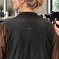 Close-up of water beading on black waterproof panel of iridescent brown zipper-front robe