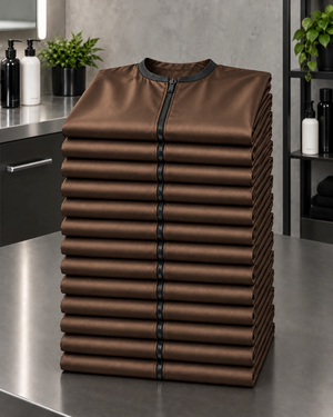 Iridescent brown zipper-front salon robes stacked in a 13-piece Baker’s Dozen bulk set