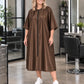 Iridescent brown zipper-front salon robe on woman standing in modern salon