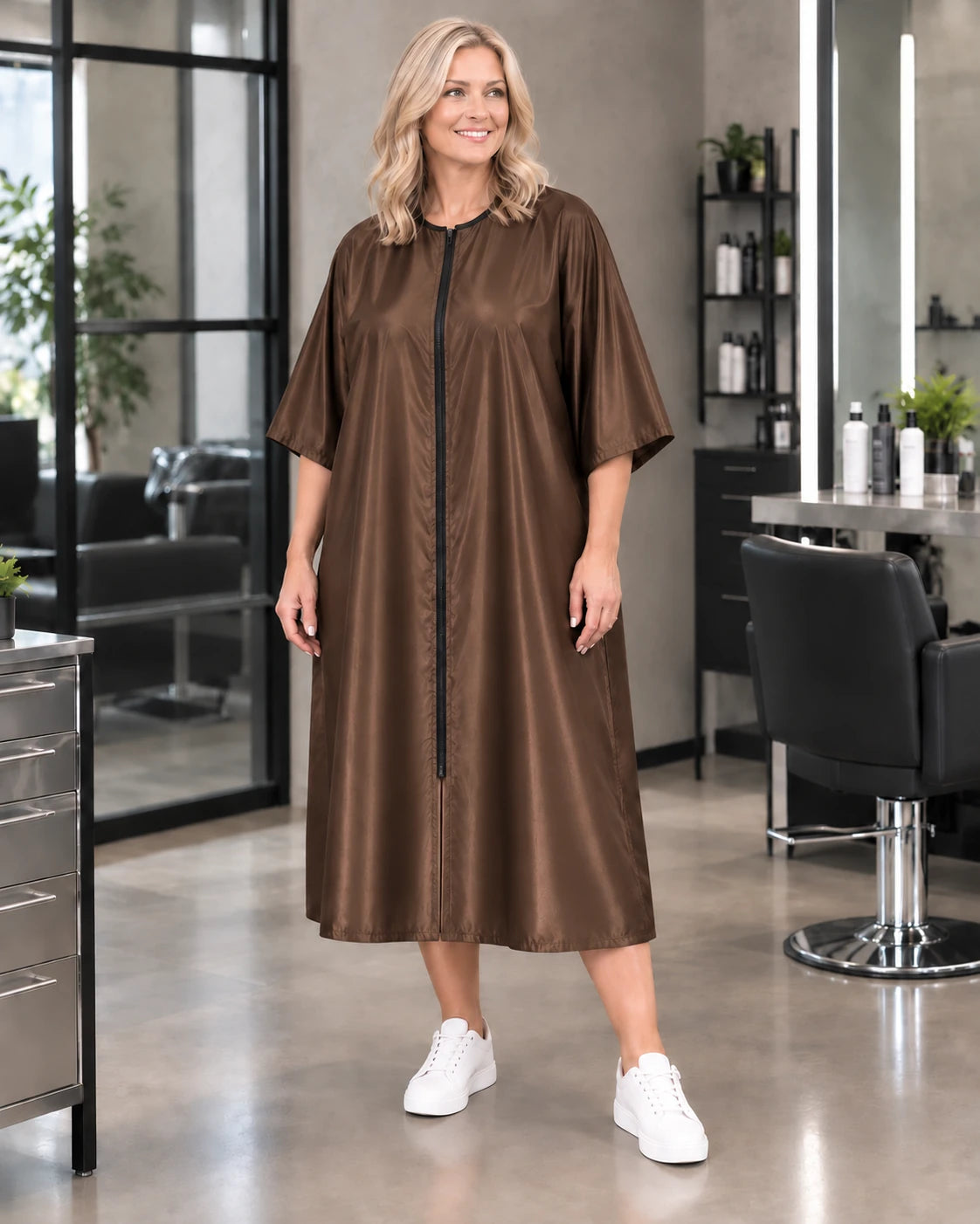 Iridescent brown zipper-front salon robe on woman standing in modern salon
