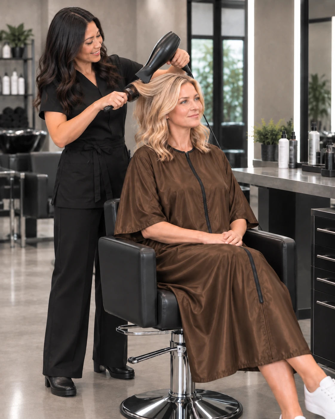 Iridescent brown zipper-front salon robe worn during professional blow-dry service
