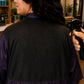 Close-up of water beading on the black waterproof back panel of an eggplant iridescent snap-front salon robe