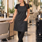 SalonCapes black iridescent apron worn by a professional Latina stylist in an upscale salon