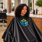 Black iridescent SalonCapes cutting cape embroidered with Triniti Salon logo