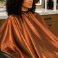 Copper iridescent SalonCapes cutting cape showing reflective fabric sheen and drape