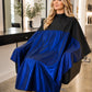 Client wearing a royal blue and black SalonCapes reversible chemical cape with full salon-service coverage